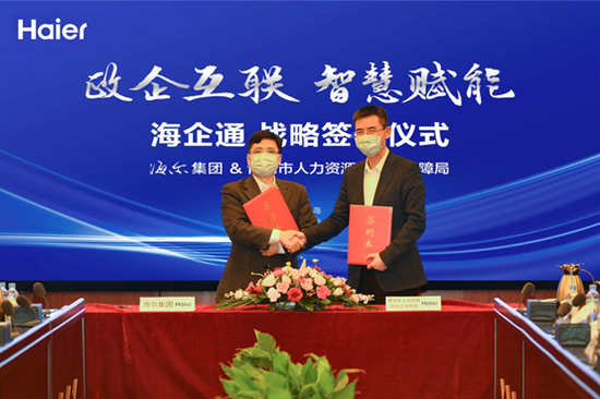 海尔集团总裁周云杰（左）与青岛市人社局局长胡义瑛（右）现场签约